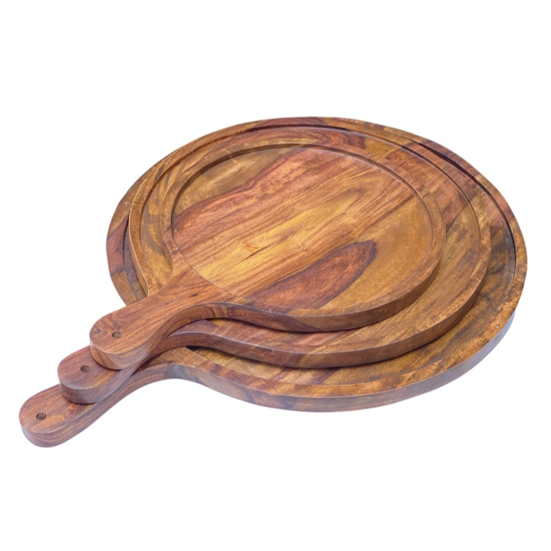 Set of three handcrafted wooden serving platters with natural acacia wood grain patterns and handles, arranged in a nested display