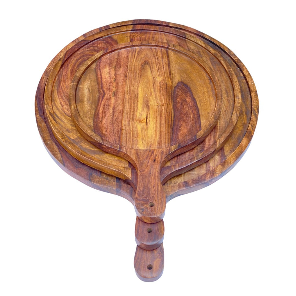 Set of three handcrafted wooden serving platters with natural acacia wood grain patterns and handles, arranged in a nested display