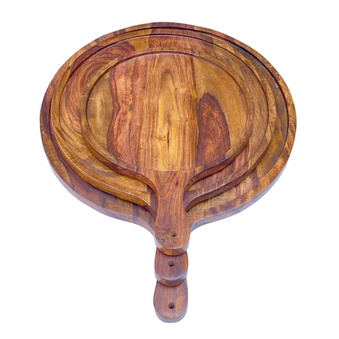 Set of three handcrafted wooden serving platters with natural acacia wood grain patterns and handles, arranged in a nested display