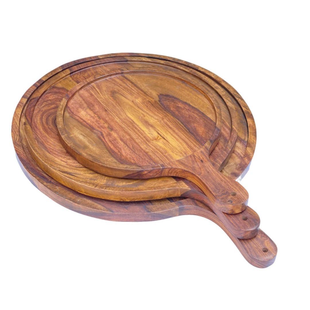 Set of three handcrafted wooden serving platters with natural acacia wood grain patterns and handles, arranged in a nested display
