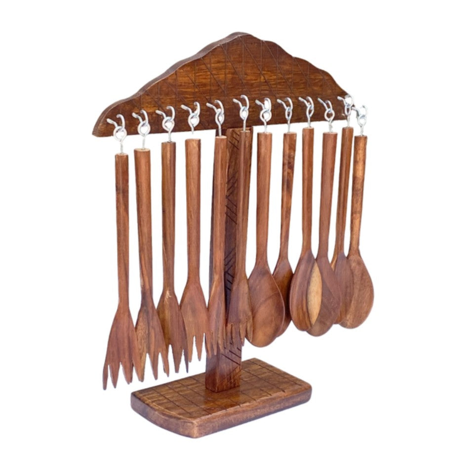 Wooden table spoons and forks hanging on carved wooden display stand - handcrafted cutlery set.