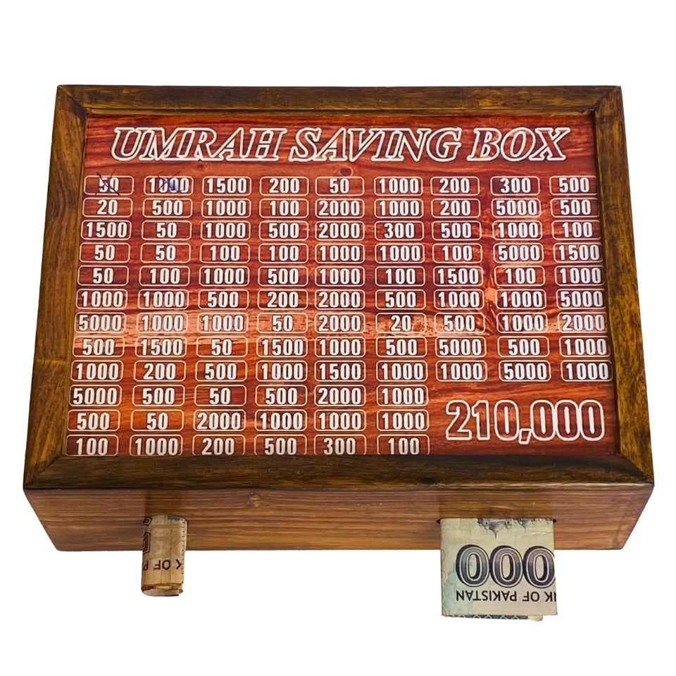 Wooden Umrah Saving Box with numbered compartments for Pakistani Rupee amounts on red background. Traditional Islamic savings method for pilgrimage fund with 210,000 PKR goal.